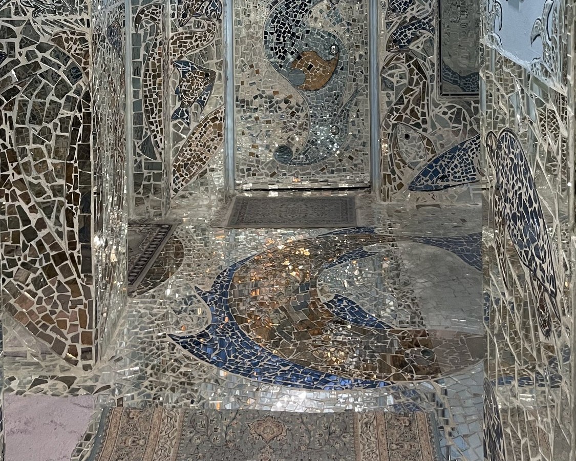 A mirrored doorway above the fish-mosaic floor